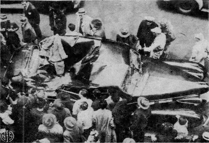 Curious onlookers surround the wrecked car, click for larger image